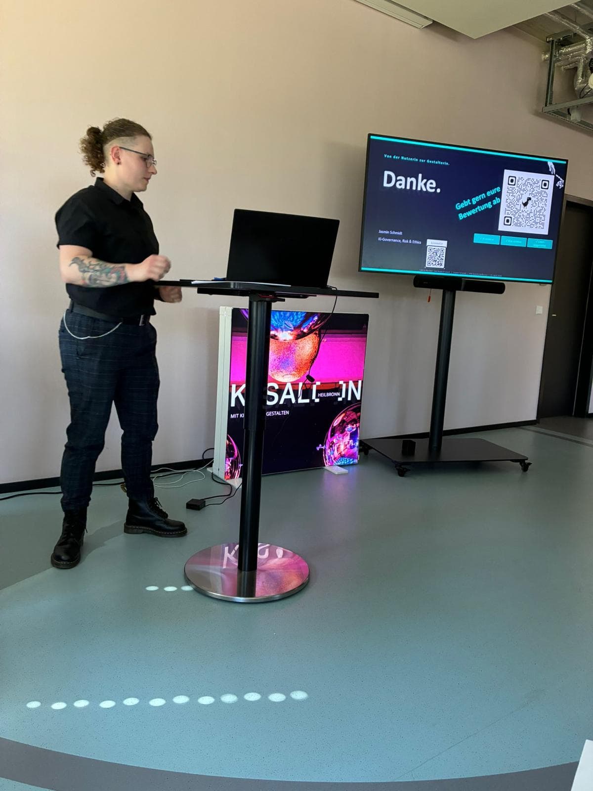 Jasmin Schmidt am Stehpult im KI Salon Heilbronn, auf dem Bildschirm die Abschlussfolie mit dem Wort Danke